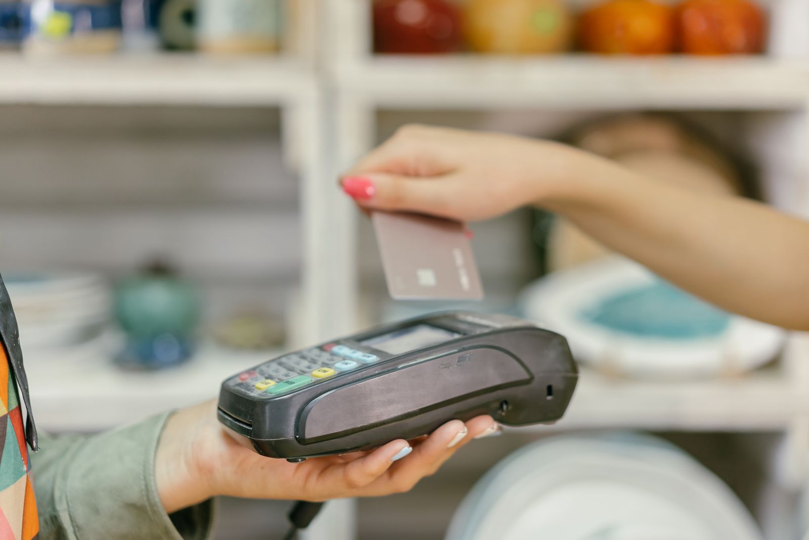 Close-up of a contactless card payment at checkout, representing consumer spending data