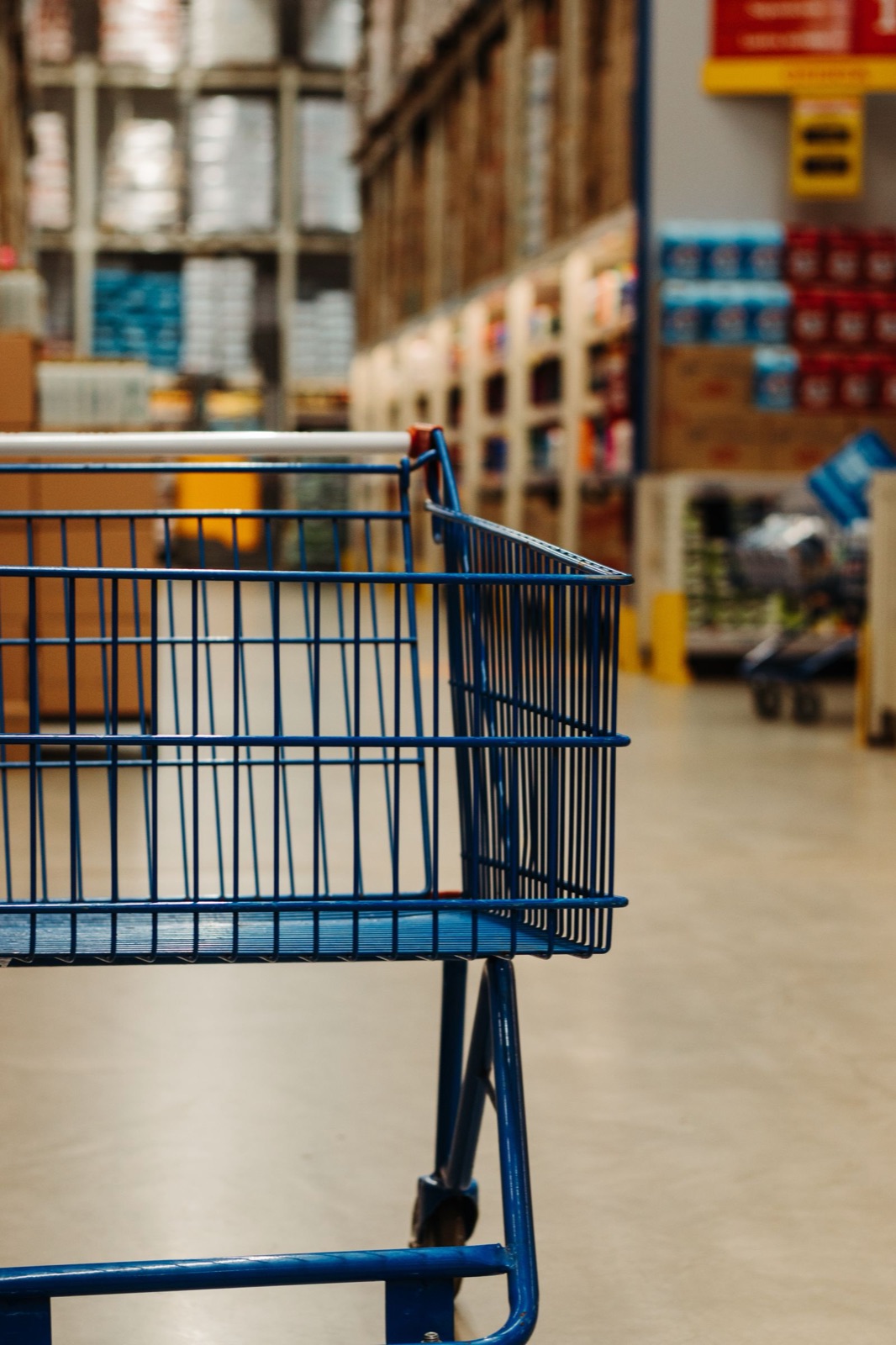 Empty shopping cart in a supermarket aisle, representing consumer prices and U.S. inflation data