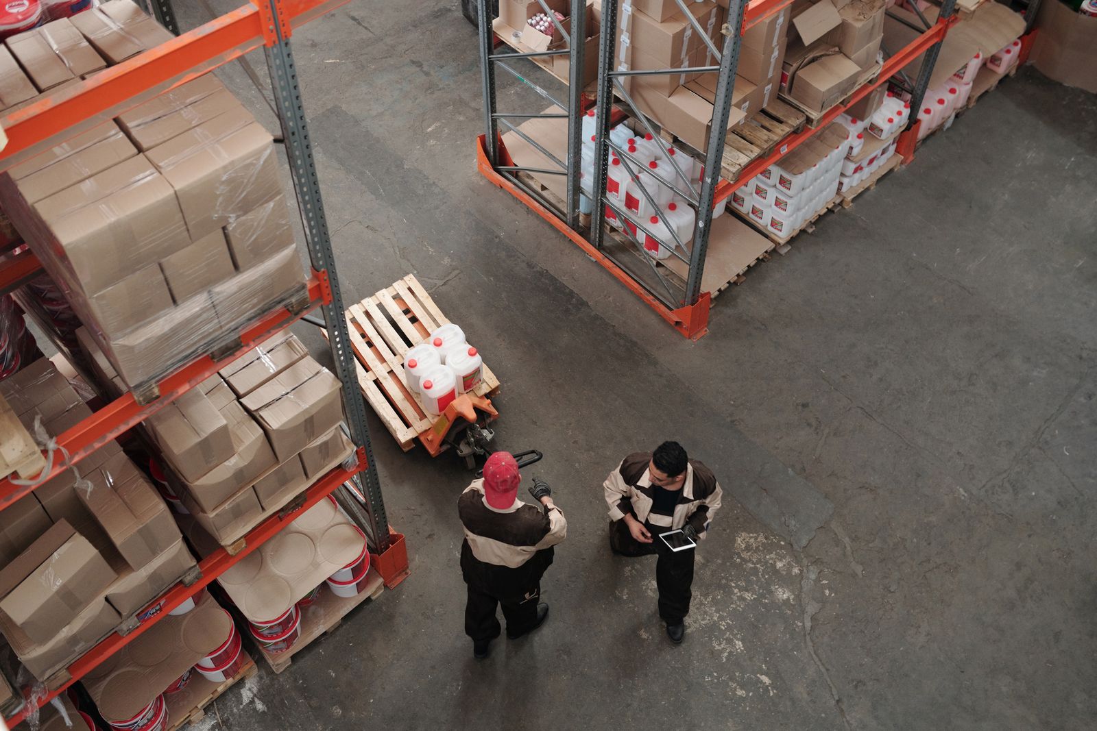 High-angle view of warehouse workers reviewing inventory, representing U.S. employment and labor market data
